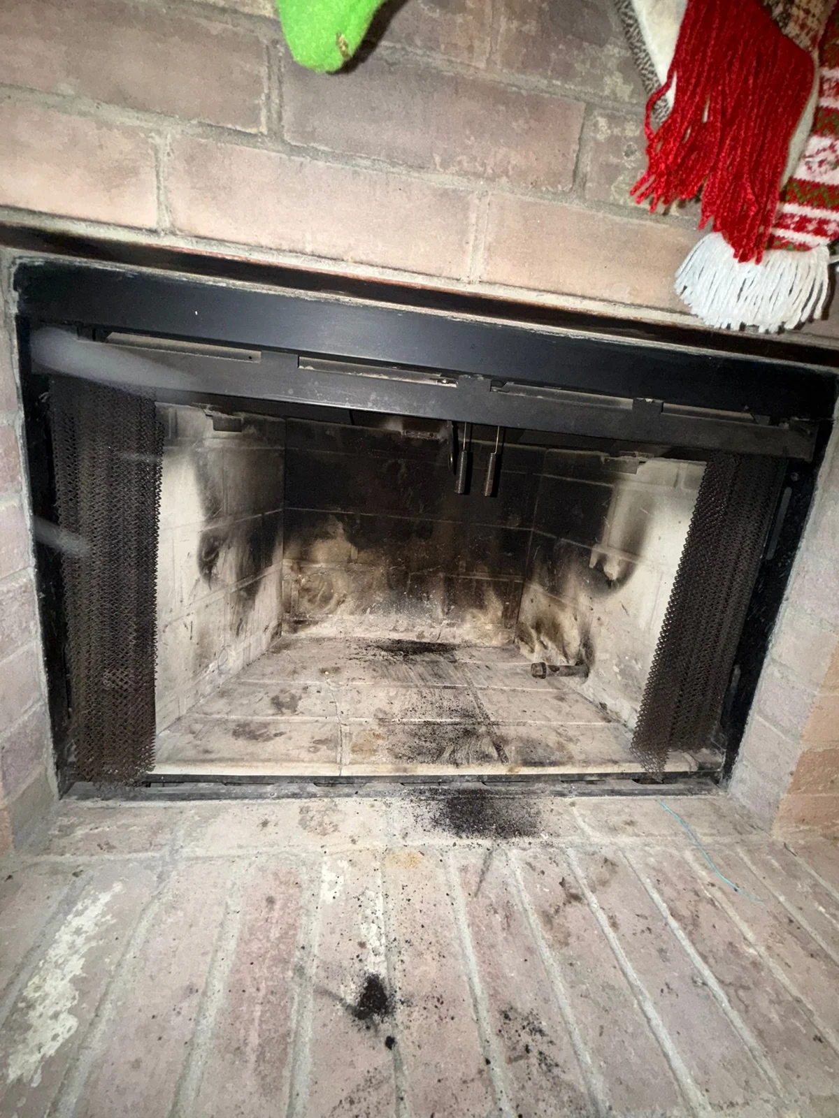 Client photograph of soot marks and debris in a brick firebox before work