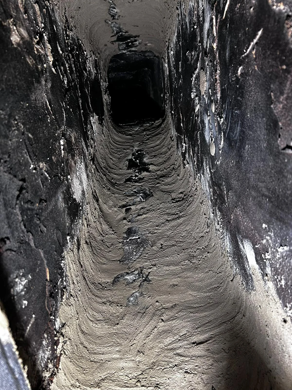 Client photograph looking through a rectangular chimney passage with rough visible deposits